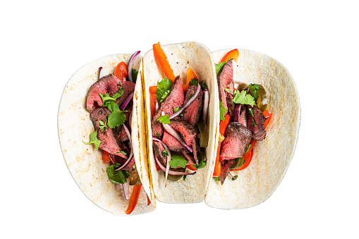 Homemade Mexican Steak Steet Tacos with Cilantro, green sauce, jalapenos and onion.  Isolated on white background.