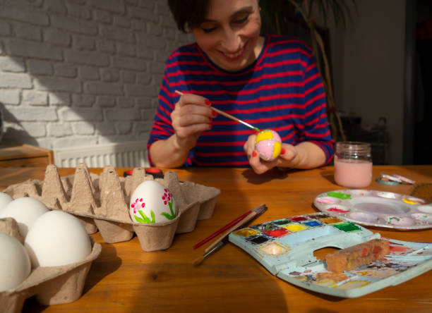 istock Woman painting Easter Egg and preparing for Easter holiday celebration 1474331279