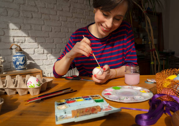 istock Woman painting Easter Egg and preparing for Easter holiday celebration 1474331319