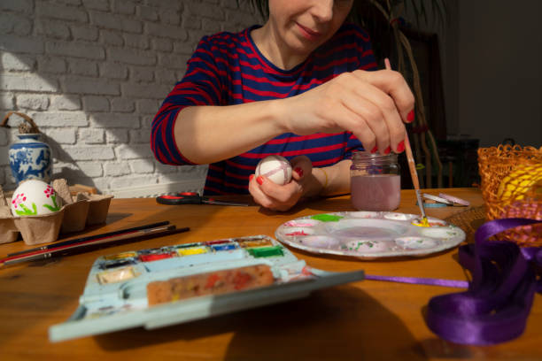 istock Woman painting Easter Egg and preparing for Easter holiday celebration 1474332265