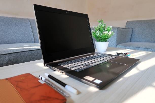 Laptop on the table with note book and ballpoint pen