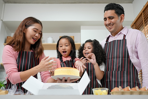 Family with activities at home, Child making cake with family, Family having fun together in kitchen, Kitchen activities concept