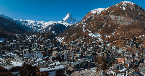 Aerial view on Zermatt Valley town and Matterhorn Peak in the background in the morning in Switzerland. Magical Swiss town with no cars and electric trains going up the mountains.