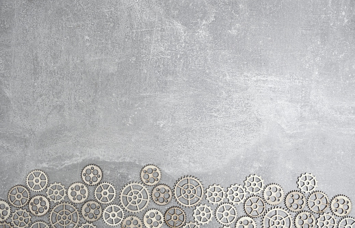 Gray concrete background with gears and copy space