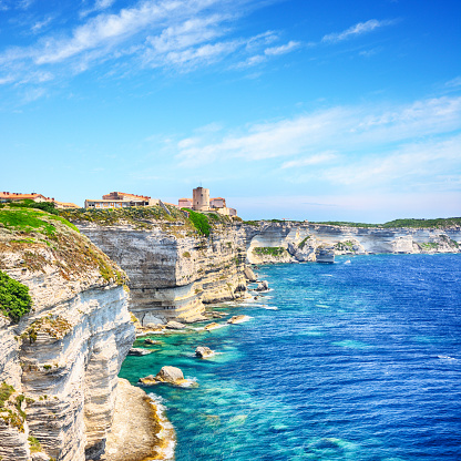 Houses of Bonifacio atop steep cliffs above the Mediterranean sea, Corsica, France. Composite photo