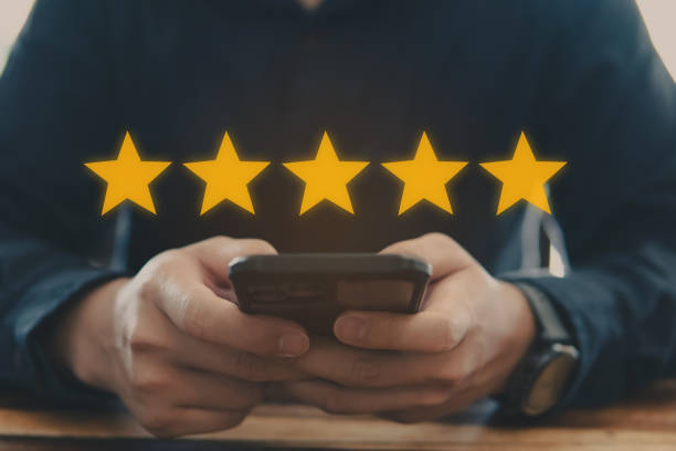 istock Customer review good rating concept, hand pressing smartphone and five star icon on visual screen for positive customer feedback 1474346942