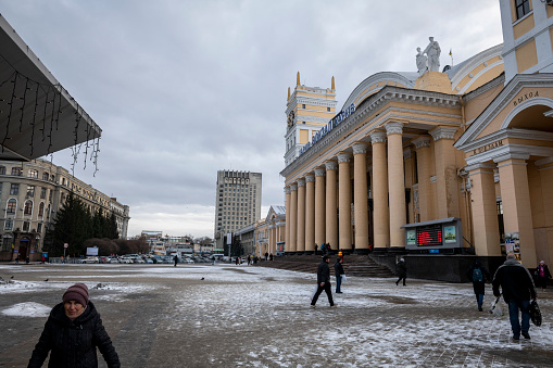 Kharkiv, Ukraine - March 1, 2023: People walk outside the Kharkiv train station on a cold winter afternoon.