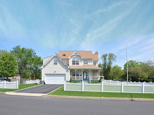 Beautiful Suburban Home White Picket Fence Beautiful Suburban Victorian Style Home Blacktop Driveway White Picket Fence Front Yard Grass Lawn Curb Street Sunny Blue Cloudy Sky Day picket fence stock pictures, royalty-free photos & images