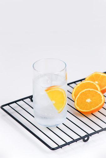 Sliced orange in a glass on a white background