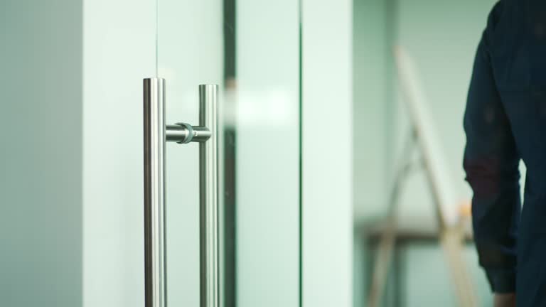 Close up hand of successful businessman open the glass office entrance in the modern business centre