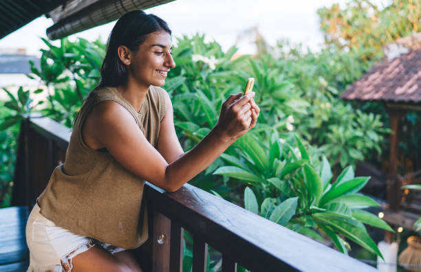 istock Content ethnic woman browsing smartphone on balcony 1474354538