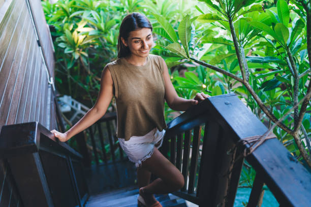 istock Cheerful woman standing up on staircase in daylight 1474354542