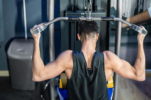 A portrait of a handsome young athlete is having exercise training in a gym.