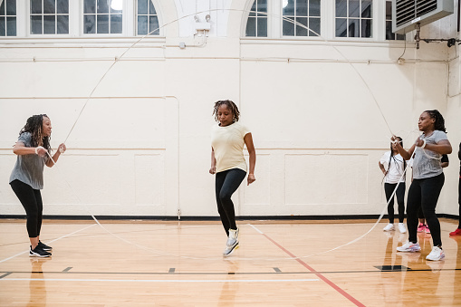 Middle Age African-American (Black) Women exercising by jumping rope in a gym