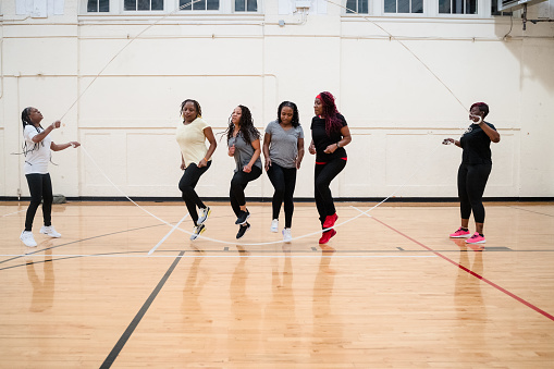 Middle Age African-American (Black) Women exercising by jumping rope in a gym