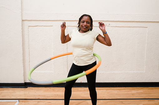 Middle Age African-American (Black) Women exercising by using a hula hoop