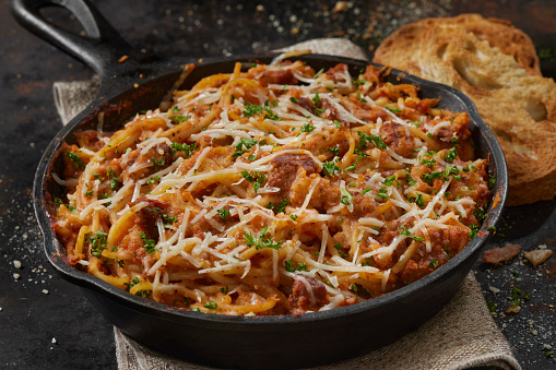 Baked Spaghetti with Spicy Italian Sausage Bolognese in a Cast Iron Skillet
