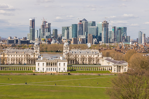 UK, London - 05 April 2019: View of the Queen House at center and Canary Wharf from Greenwich Park. City of London in the background.