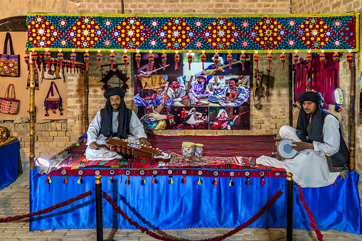 Quetta, Pakistan - February 19, 2020: Balochi folk singers and musicians are performing on a stage in Quetta, Pakistan. They are dressed in traditional Balochi clothing. 
The performers are playing traditional Balochi instruments tabla, dhol, and sarangi, creating lively and energetic music with fast rhythms and complex melodies. The singers are singing in the Baluchi language, sharing stories about love, nature, and everyday life with passion and emotion.
Overall, the photo captures the joy and beauty of Baluchi folk music. It's a powerful reminder of the importance of preserving and celebrating traditional art forms as a way of connecting people and fostering cultural understanding.