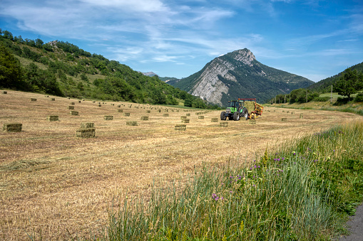 Tractor picking up bales of hay