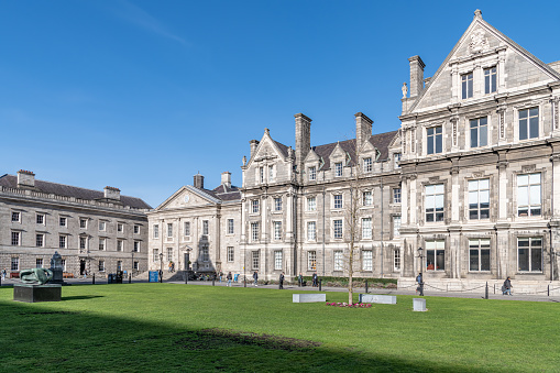 Caernarfon,North Wales,UK-March 17 2022: One of the greatest buildings of the Middle Ages,with polygonal towers, eagle statues and multi-coloured masonry,on a sunny spring day.