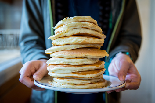 Young girl holding stack of buttermilk pancakes