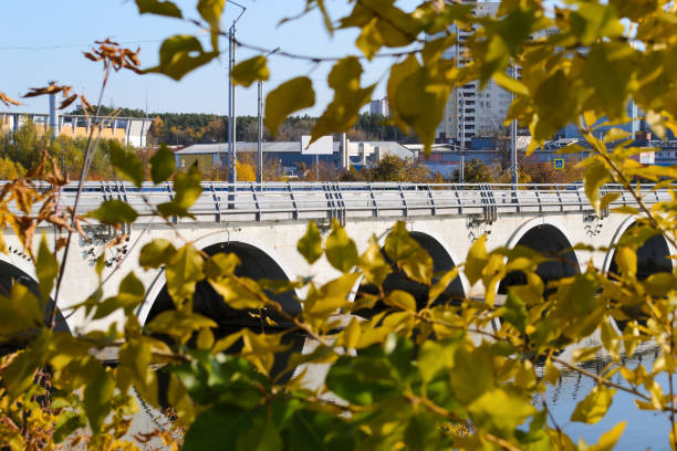 istock View through the autumn foliage on a modern arched bridge across the river 1474366685