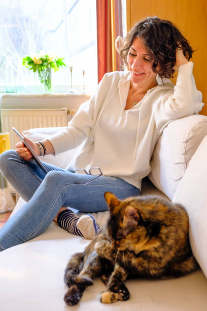 istock Smiling woman with cat chatting on notepad 1474376676
