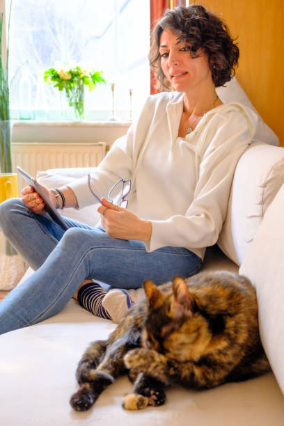 istock Beautiful woman with cat on sofa 1474376695