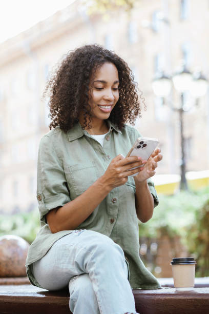 istock Happy woman using smart phone in a city 1474376930