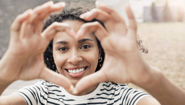 istock Smiling woman making a heart shape with hands closeup 1474376931