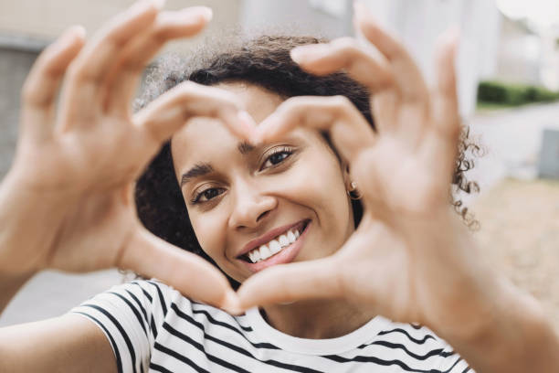istock Smiling woman making a heart shape with hands closeup 1474376985