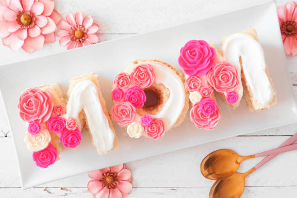Muttertag MOM-Kuchen mit rosa und weißen Bonbonblüten – Foto