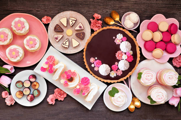 istock Mothers Day table scene with assorted desserts and sweets, overhead on dark wood 1474377837