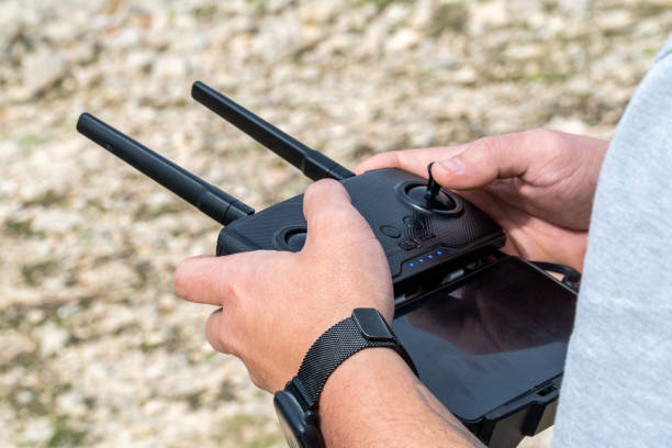 istock male hands using a drone joystick outdoors 1474378200