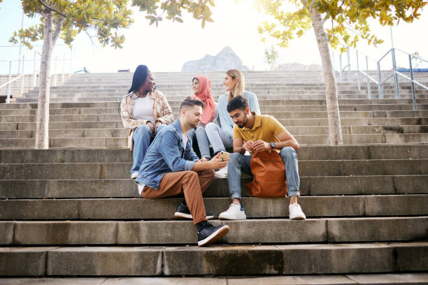 istock Relax, phone or students on steps at lunch break talking or speaking of future goals or education on campus. Social media, school or happy friends in university or college bonding in fun conversation 1474378397