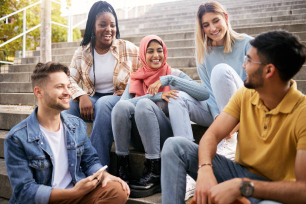 istock Relax, happy or students on steps at break talking or speaking of future goals or education. Diversity, school or funny friends in university laughing or bonding in conversation on college campus 1474378405