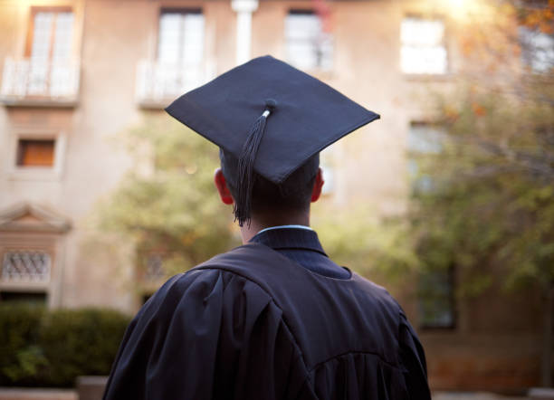 Thinking graduate, man or vision on university campus, college event or school graduation ceremony and future goals. Graduation cap, robe or student with education, learning or employment opportunity