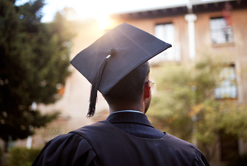 Black man, graduation cap and ideas on university campus, school and college with employment opportunity goals. Thinking student, graduate and hope in graduation ceremony and education learning event