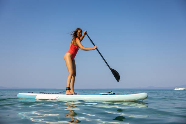 istock Young Caucasian woman exploring sea with standup paddle board 1474382803