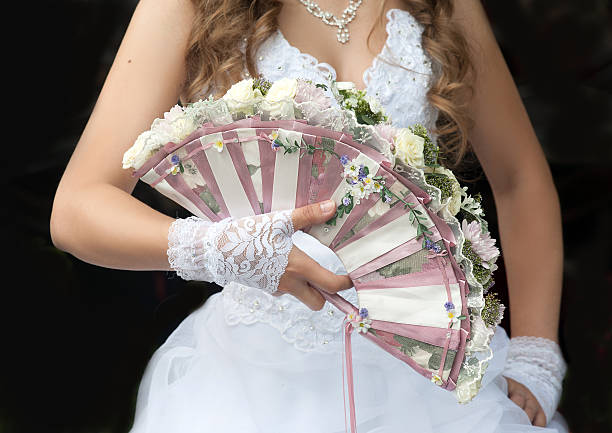 Original wedding fan-bouquet decorated with roses in the bride’s hands