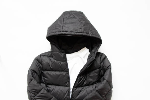черная пухлая зимняя куртка лежит на белом фоне, модная зимняя одежда - puffed sleeve стоковые фото и изображения