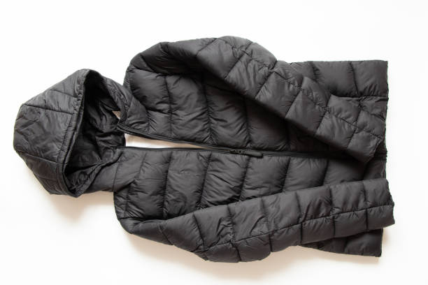 jaqueta de inverno preta inchada encontra-se em um fundo branco, roupas de inverno elegantes - puffed sleeve - fotografias e filmes do acervo