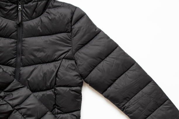 jaqueta de inverno preta inchada encontra-se em um fundo branco, roupas de inverno elegantes - puffed sleeve - fotografias e filmes do acervo
