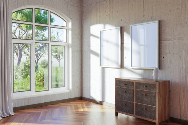 istock empty canvas poster mock up hanging on a wall; empty living room interior; bright daylight shining through a large window; home decoration desing; 3D Illustration 1474386160