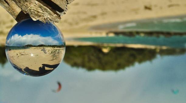 istock through the looking glass - somewhere under a rainbow, wind surfers have paradise on a beach on the island of maui, hawai'i. (abstract) 1474390788