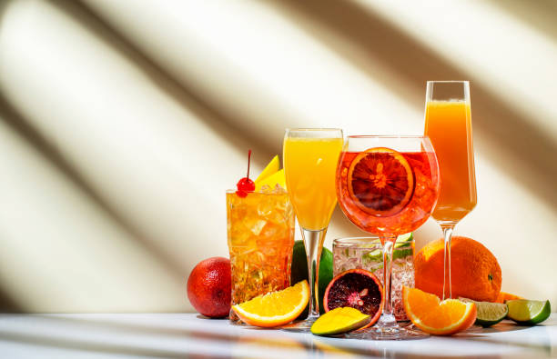 cocktails de fruits d’été et d’agrumes pour la fête, boissons rafraîchissantes à faible teneur en alcool avec vin, champagne et rhum. fond beige, lumière dure, motif d’ombre - whisky cocktail glass rum photos et images de collection