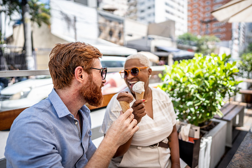 Mature couple eating ice cream on a date outdoors