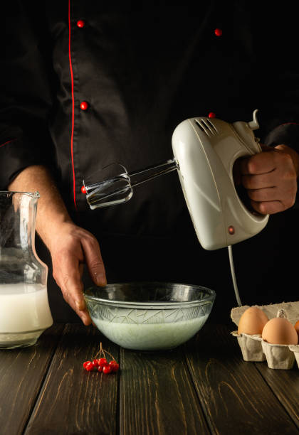 istock Cooking an egg omelette with milk using an electric hand mixer. Delicious breakfast by the hands of the chef in the kitchen 1474396113