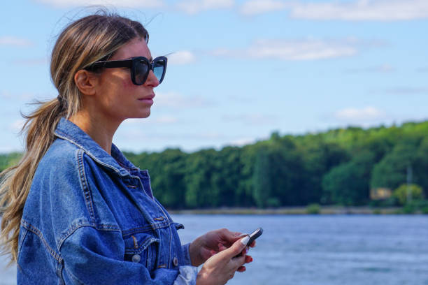 istock A woman using mobile phone against lake 1474396120